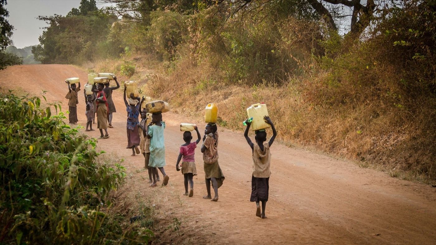 Children walking a dirt road during an outreach